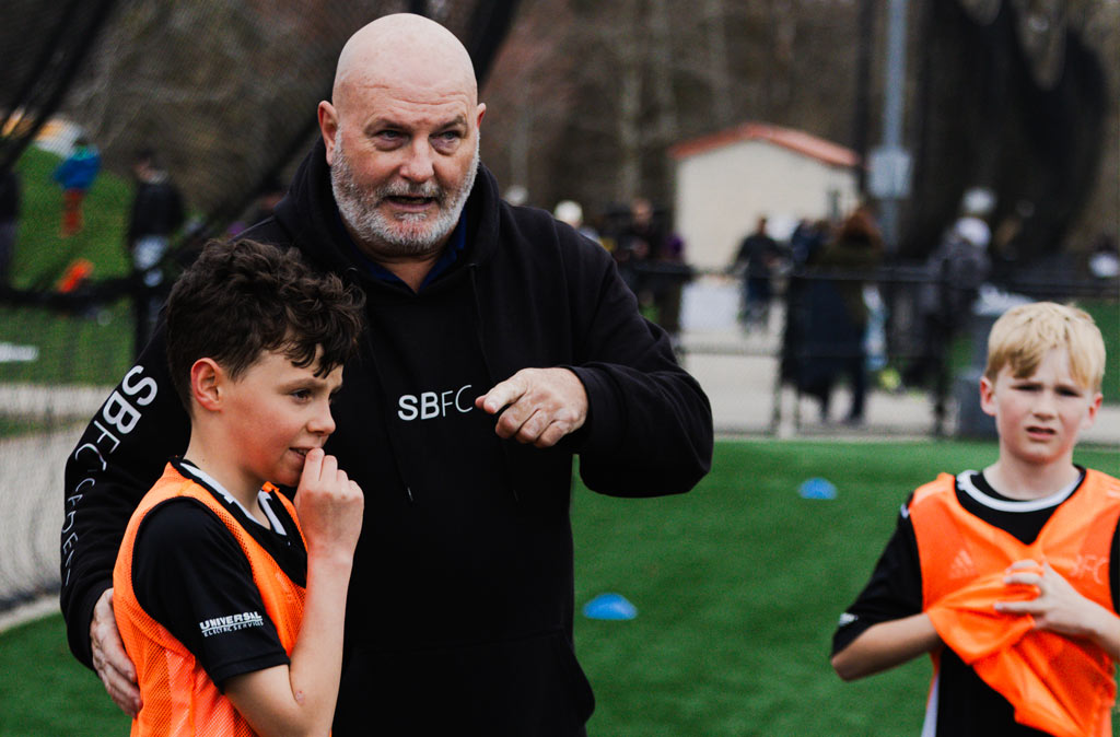 Coach David offering instruction to BU11 player on the sideline