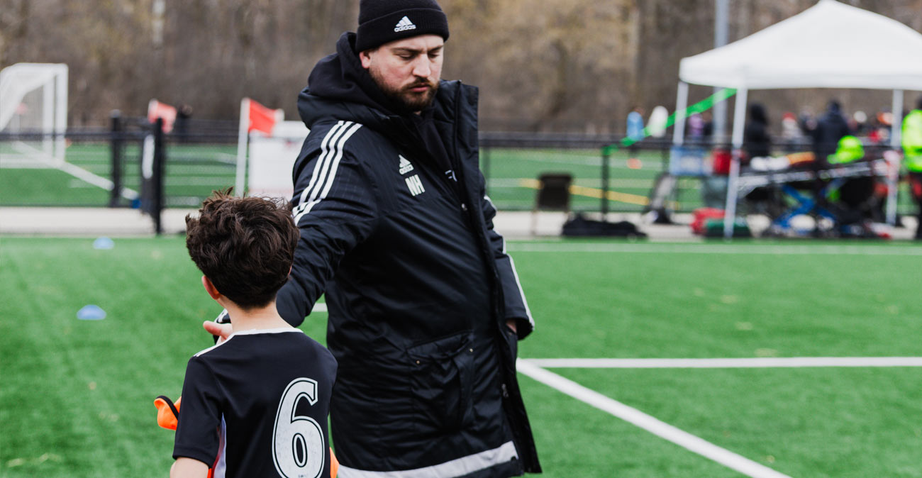 Coach Nolan giving a high five to BU11 player substituting out of the game